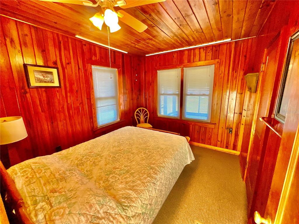 106 Sunny Side Beach Road Hawthorne, FL 32640 - Photo 15 of 54 a bed sitting in a bedroom next to a window