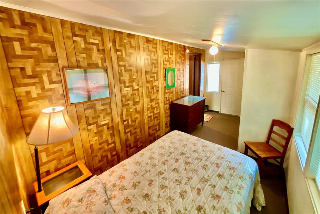 106 Sunny Side Beach Road Hawthorne, FL 32640 - Photo 22 of 54 a bedroom with a bed and wooden floor
