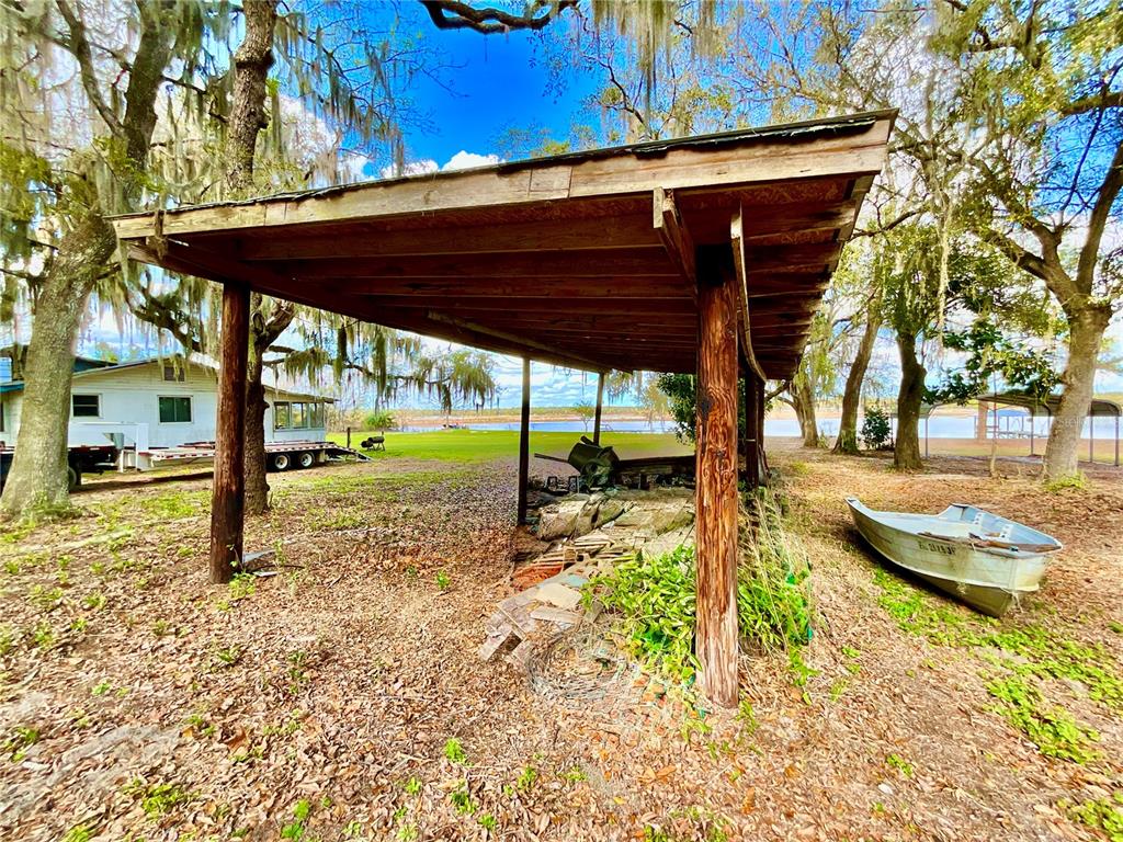 106 Sunny Side Beach Road Hawthorne, FL 32640 - Photo 39 of 54 a view of a backyard with table and chairs under an umbrella