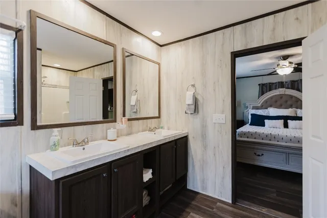a en suite bathroom with a granite countertop sink and a mirror