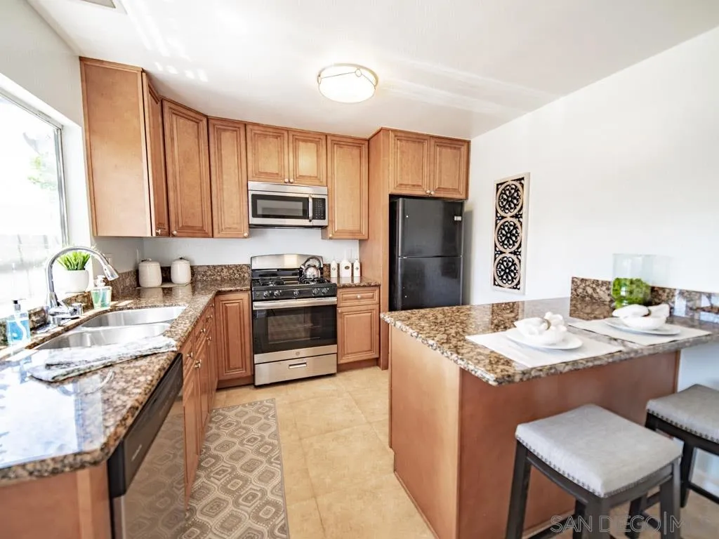 10911 Eddington Road Santee, CA 92071 - Photo 5 of 25 a kitchen with stainless steel appliances granite countertop a stove refrigerator sink and a refrigerator
