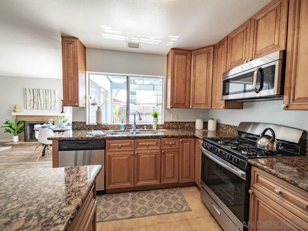10911 Eddington Road Santee, CA 92071 - Photo 6 of 25 a kitchen with stainless steel appliances granite countertop a stove a sink and a microwave
