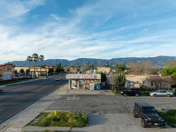 a view of a city street with a car parked on the side of the road