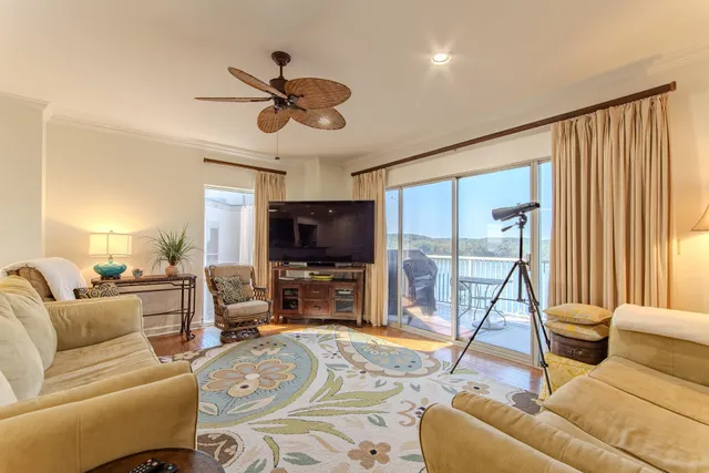 a living room with furniture a flat screen tv and a large window