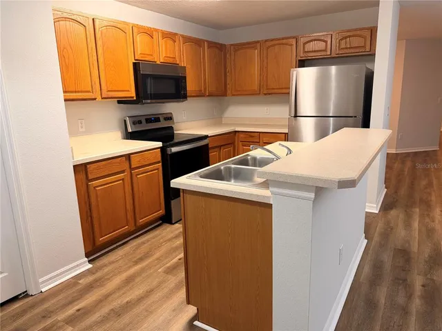 a kitchen with stainless steel appliances a refrigerator a stove a microwave and cabinets