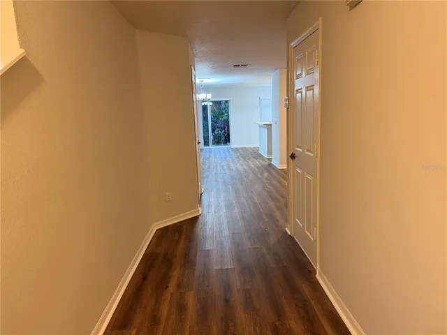 a view of empty room with wooden floor