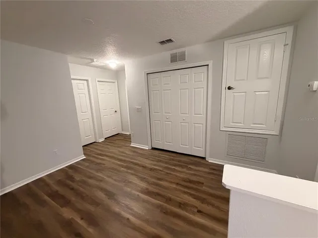a view of a room with wooden floor and entryway