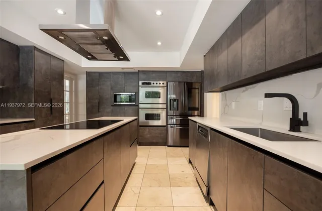a large kitchen with granite countertop a large counter top and sink