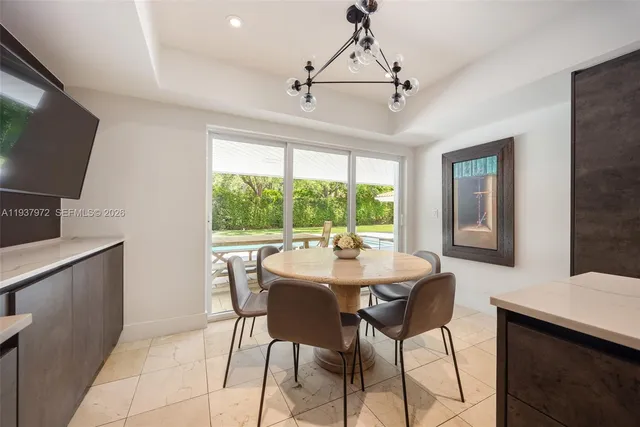 a dining room with furniture a chandelier and window