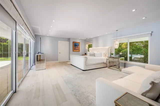 a view of a bedroom with furniture and large windows