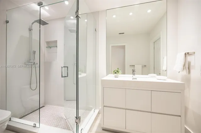 a bathroom with a shower sink and mirror