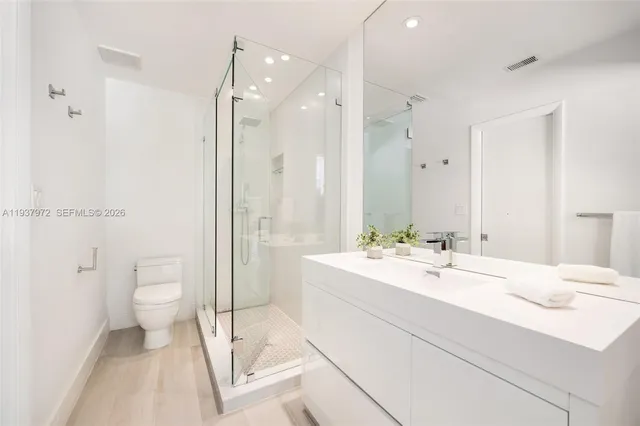 a bathroom with a double vanity sink toilet and shower