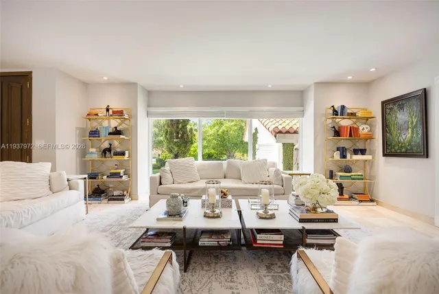 a living room with furniture large window and table