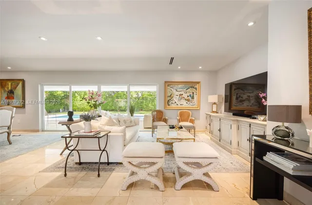 a living room with furniture a flat screen tv and a floor to ceiling window
