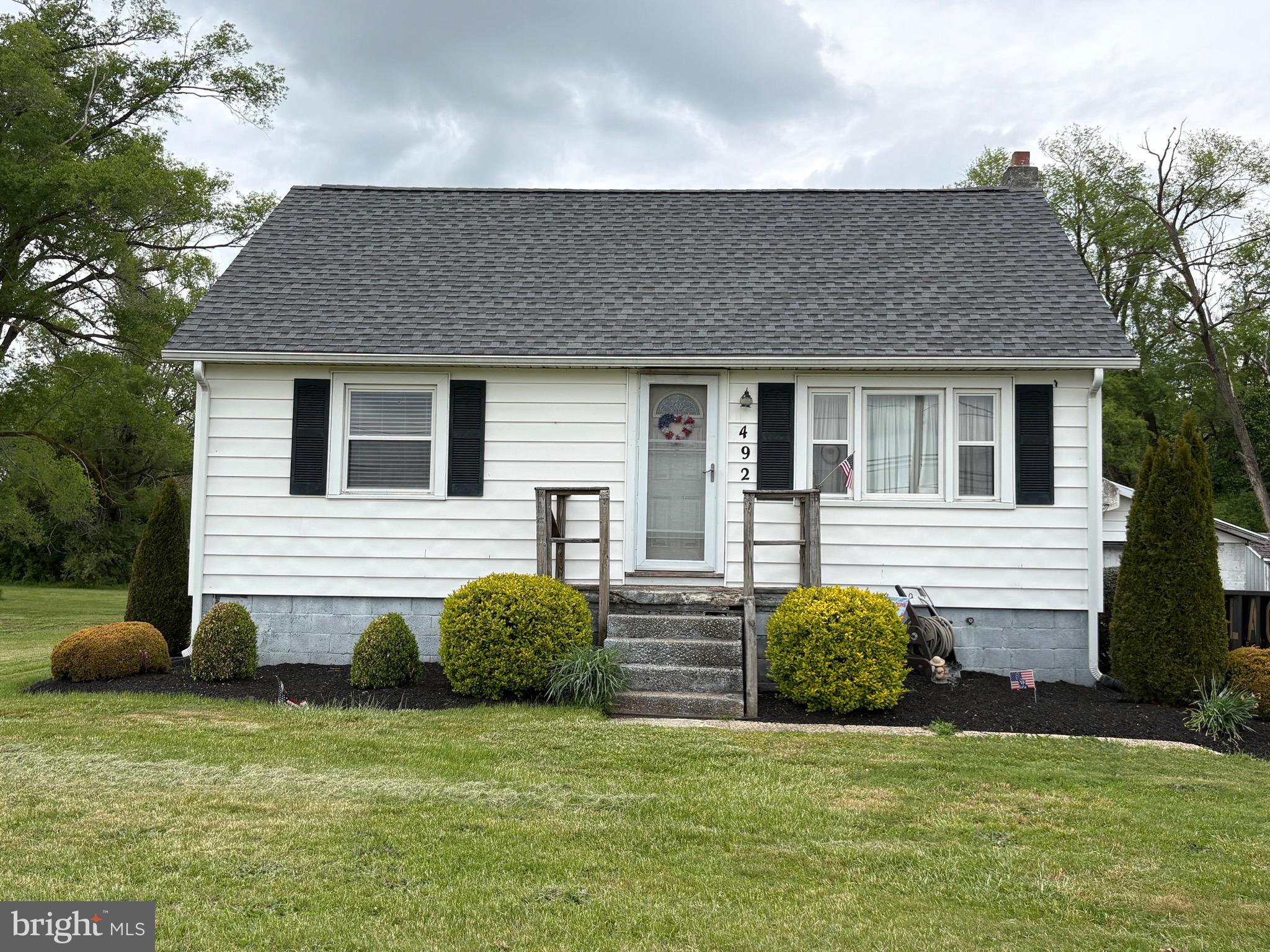 492 Highway 40 Elmer, NJ 08318 - Photo 2 of 30 a front view of a house with a garden