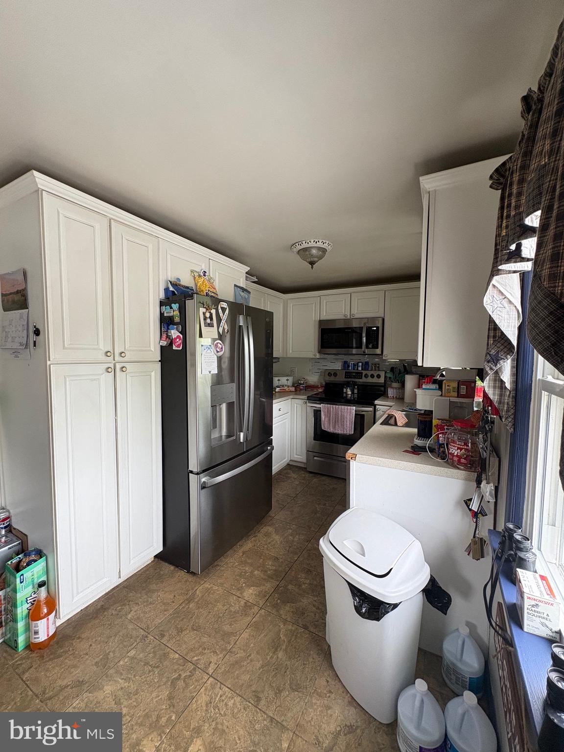 492 Highway 40 Elmer, NJ 08318 - Photo 6 of 30 a kitchen with stainless steel appliances a refrigerator a sink a stove and white cabinets