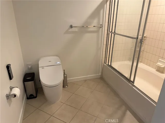 a white toilet sitting next to a shower