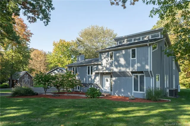 a front view of a house with a yard and a tree