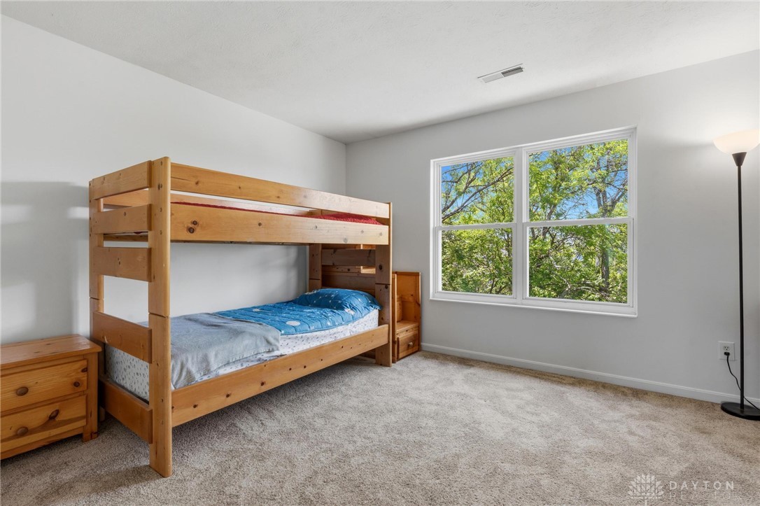 70 Martin Lane Springboro, OH 45066 - Photo 33 of 69 This spacious bedroom offers serene views through expansive windows, inviting natural light.