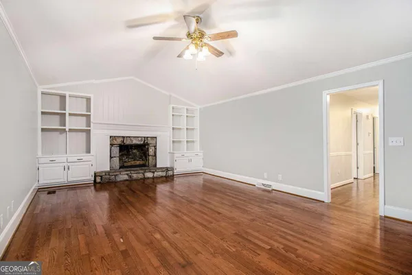 a view of empty room with a fireplace and wooden floor
