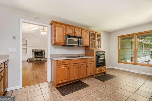 a kitchen with granite countertop a stove a sink and a microwave