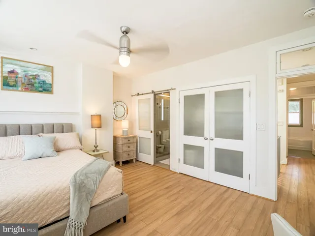 a bedroom with a large bed and a chandelier
