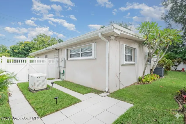 a front view of a house with a yard and potted plants