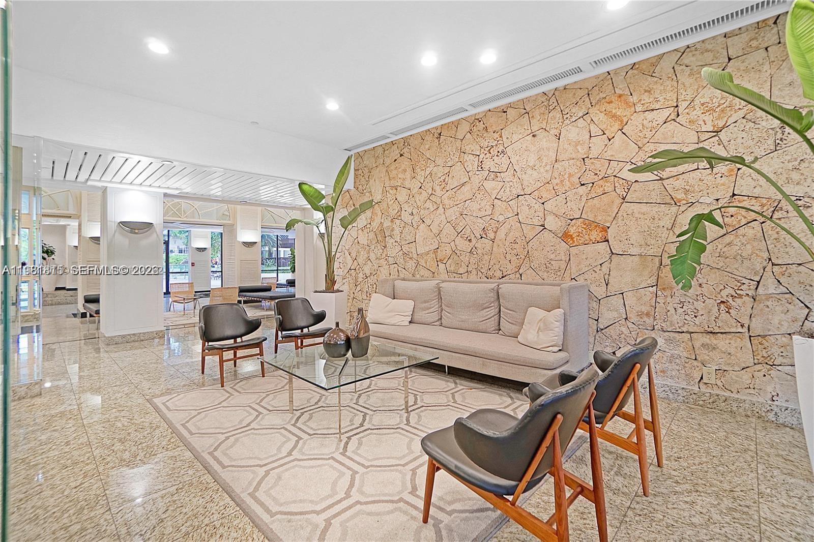 780 Northeast 69th Street, Unit 2201 Miami, FL 33138 - Photo 3 of 15 a living room with fireplace furniture and a large window