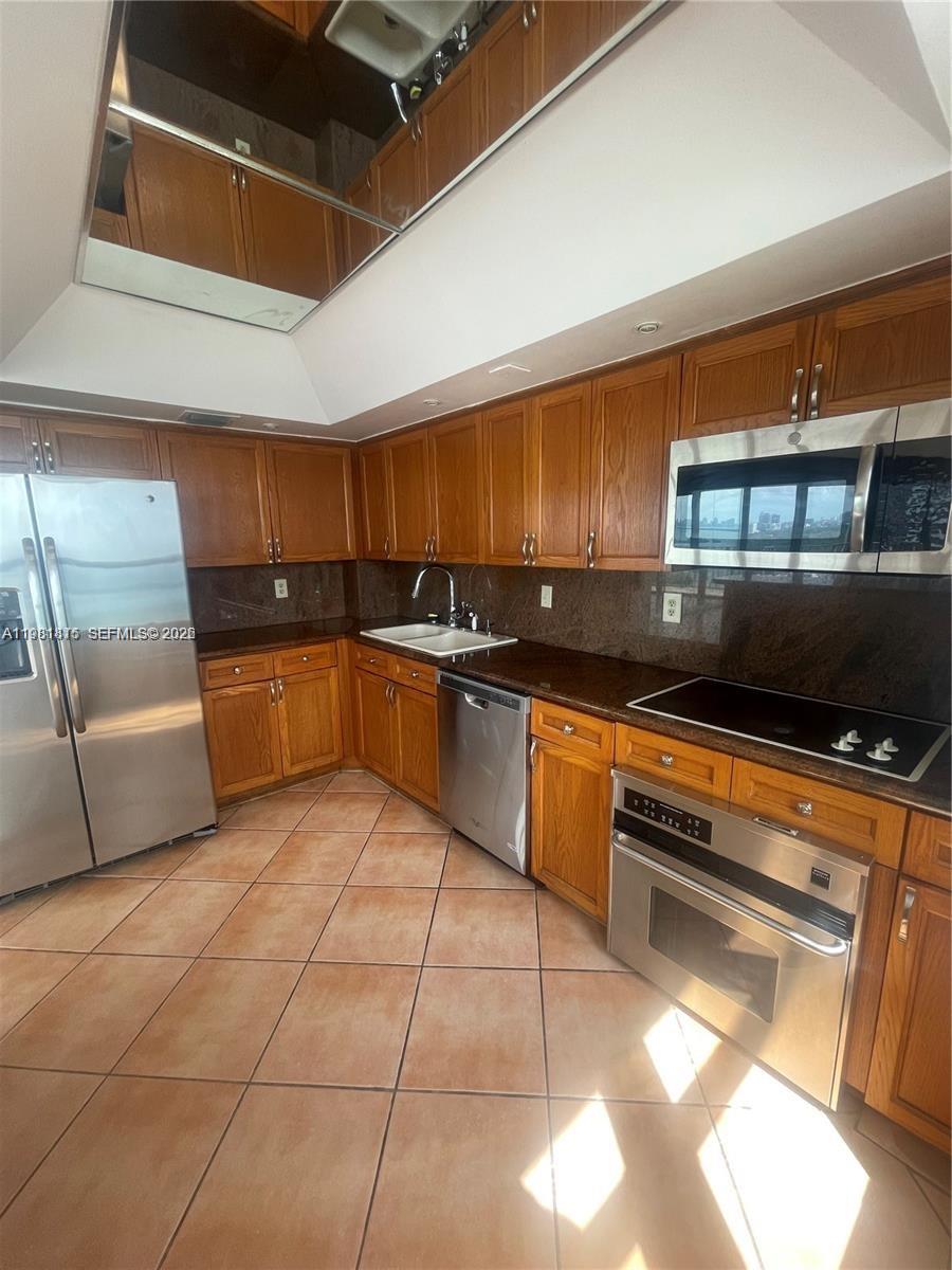 780 Northeast 69th Street, Unit 2201 Miami, FL 33138 - Photo 7 of 15 a kitchen with granite countertop a sink and a stove