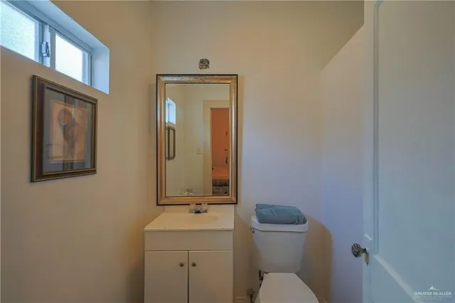 a bathroom with a toilet a sink and mirror