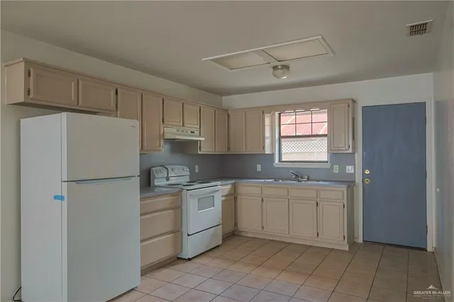 a kitchen with white cabinets and white appliances