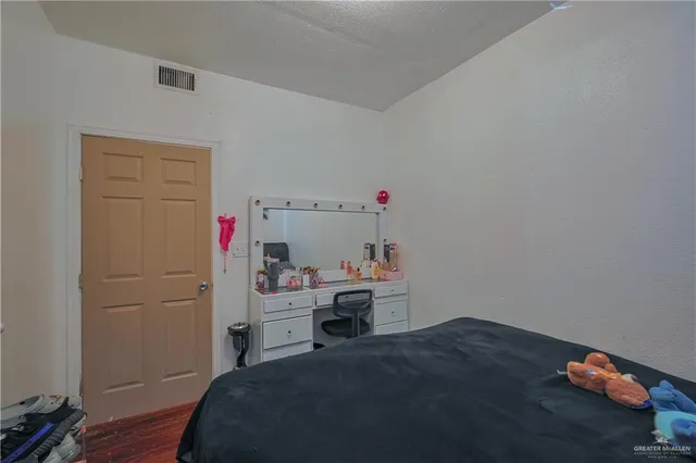 a bedroom with a bed and wooden floor