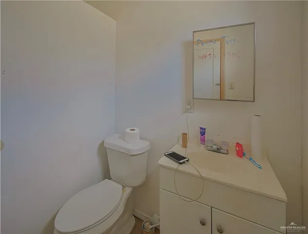 a bathroom with a toilet sink vanity and mirror