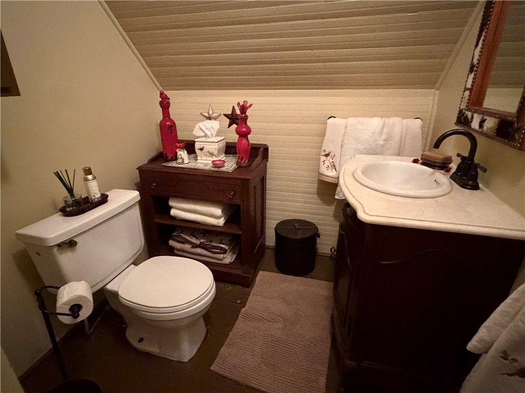 1100 Maple Calvert, TX 77837 - Photo 31 of 32 a bathroom with a toilet sink and mirror