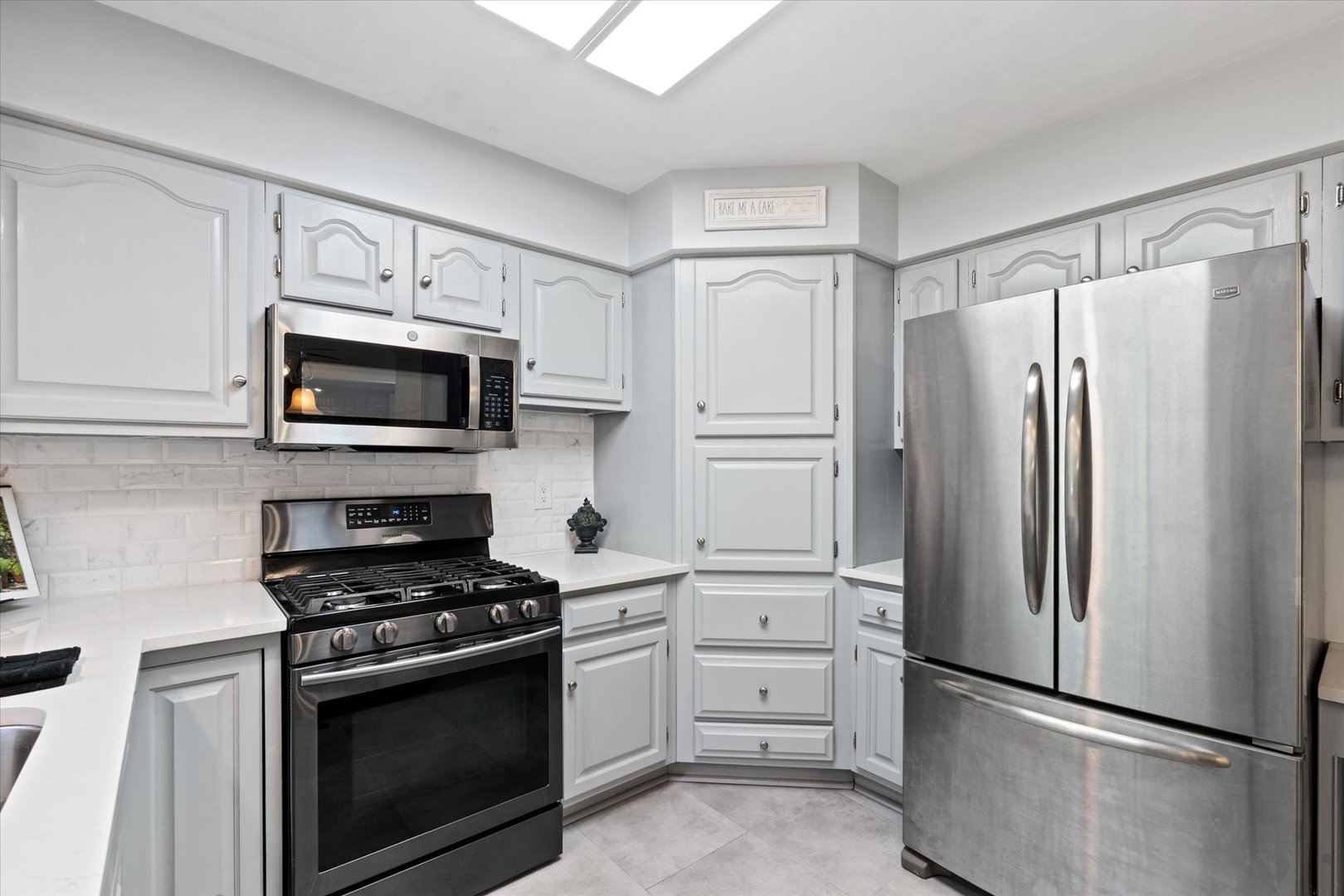 10 Oak Grove Road Geneseo, IL 61254 - Photo 10 of 43 a kitchen with white cabinets and stainless steel appliances