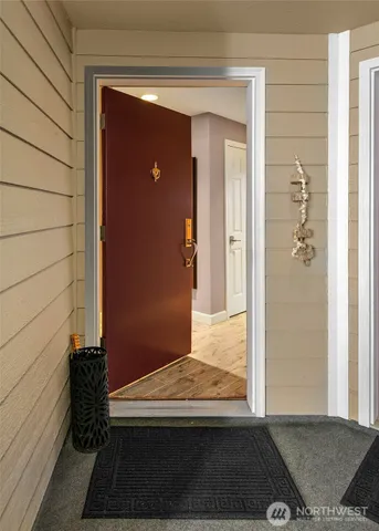 a kitchen with stainless steel appliances kitchen island granite countertop a refrigerator a stove a washer and dryer with wooden floor