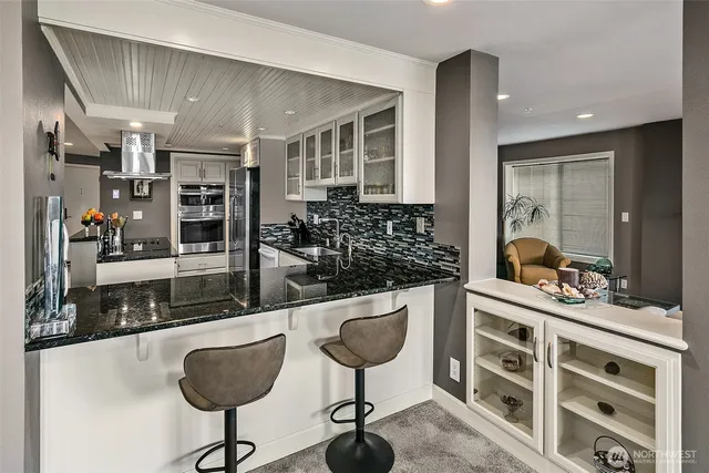 a dining room with furniture and large windows
