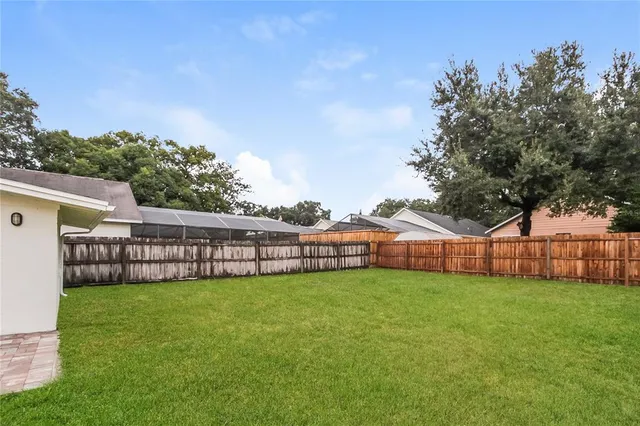 a view of a house with a big yard and large trees