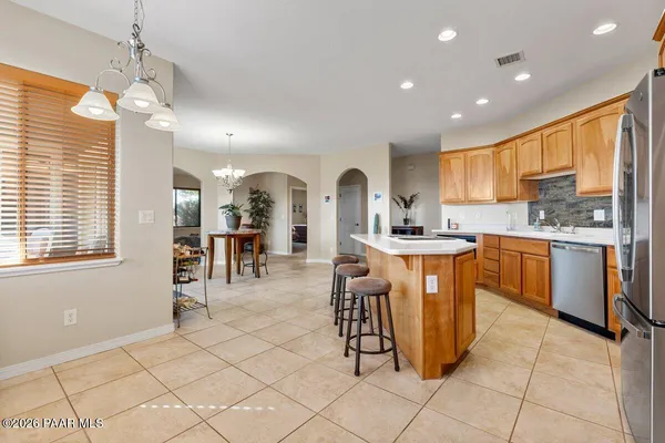 a kitchen with stainless steel appliances kitchen island granite countertop a stove a sink and a refrigerator