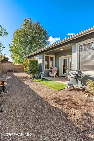 a view of a house with a yard and potted plants