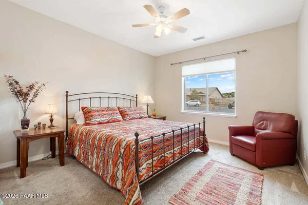 a spacious bedroom with a bed and a flat screen tv