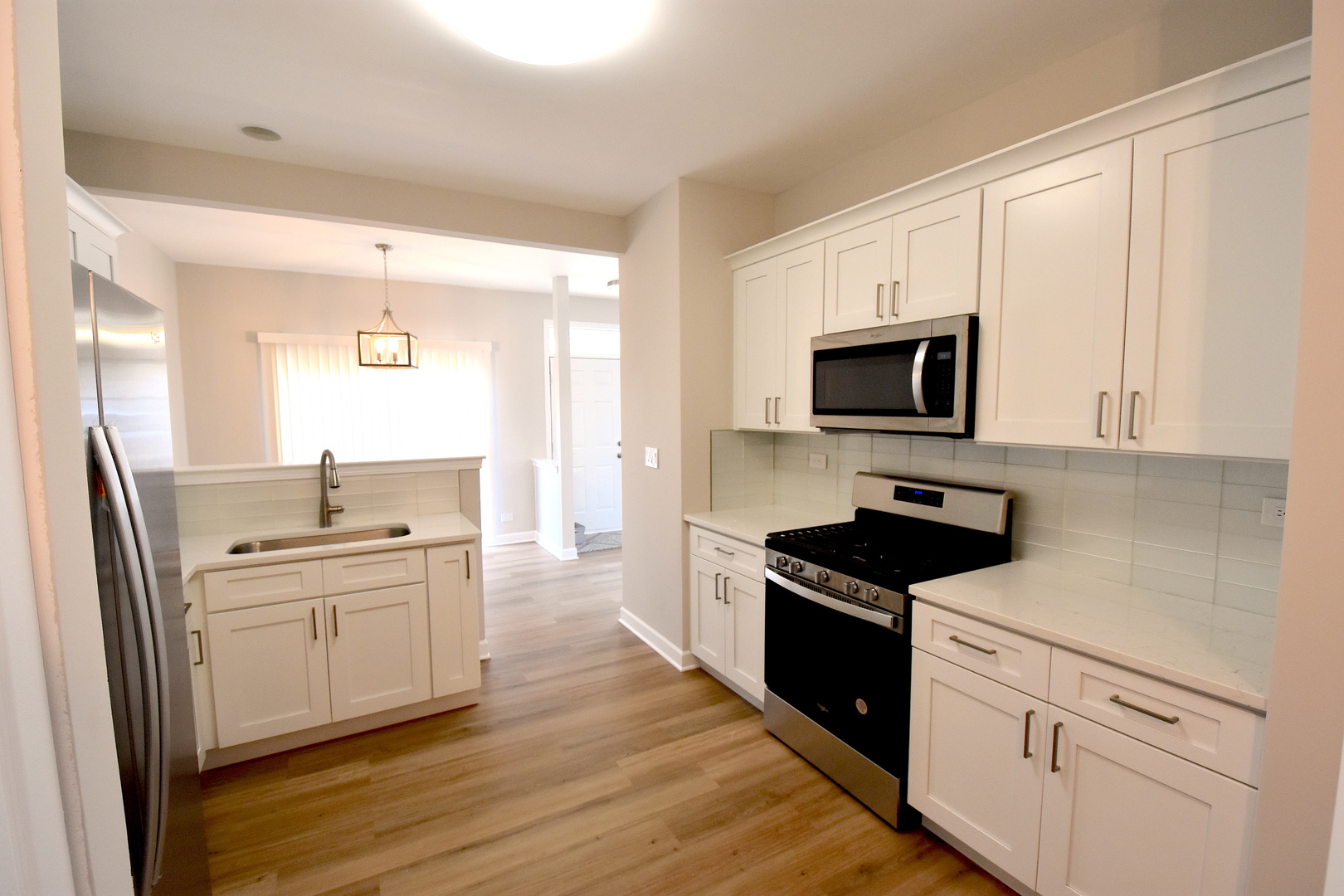 2341 Reflections Drive Aurora, IL 60502 - Photo 7 of 21 a kitchen with cabinets stainless steel appliances a sink and wooden floor