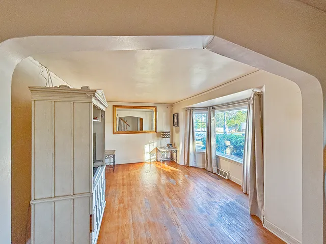 a bedroom with wooden floor and windows