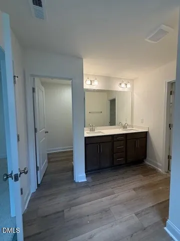 a bathroom with a double vanity sink mirror and shower