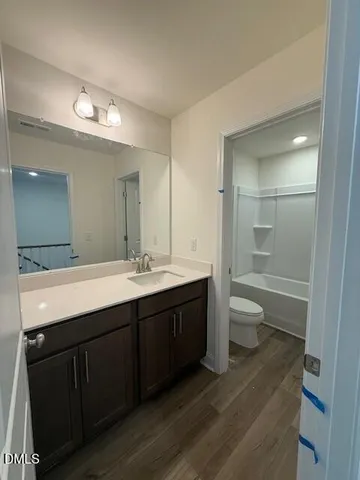 a spacious bathroom with a double vanity sink a toilet and a shower