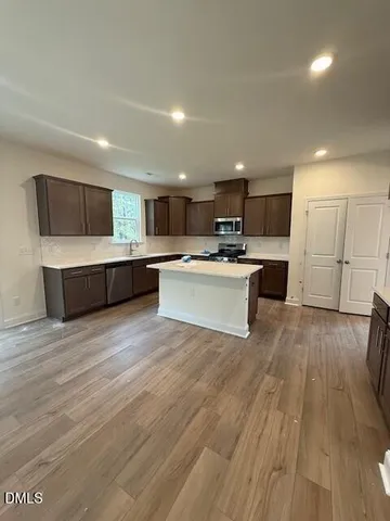 a view of kitchen with wooden floor and electronic appliances