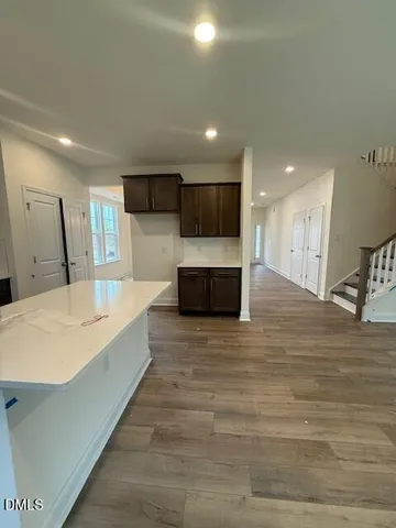 a large white kitchen with kitchen island sink and refrigerator