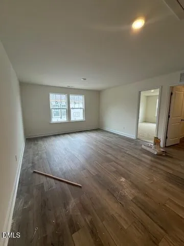 an empty room with wooden floor and window