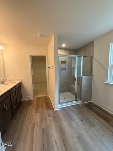 a bathroom with a glass door shower a sink and a mirror