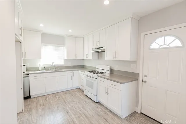 a kitchen with granite countertop white cabinets and white appliances